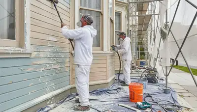 Painter sanding exterior wall for surface prep in San Francisco, CA before applying weatherproof coating